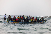 Fishermen sit in their pirogue as they set out to sea from the fishing quay, in Dakar