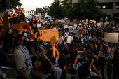 Protesters stand near a vandalized federal building, in Austin