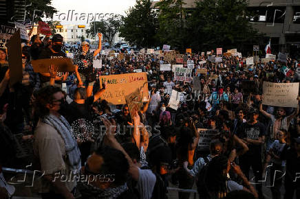 Protesters stand near a vandalized federal building, in Austin