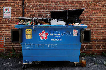 Trash is piled in a dumpster in Watertown