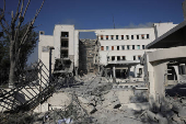 People gather near a damaged site, in Damascus