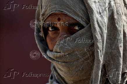 A worker wraps her head with a cloth after the completion of her shift at Deendayal Port in Kandla