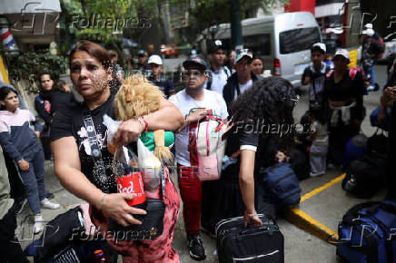 Migrants gather outside the Venezuelan embasssy waiting for a flight back to their country
