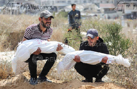 Mourners carry the bodies of children from the Al-Arabeed family killed in Israeli strikes, at a cemetery, in Gaza City