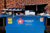 Trash is piled in a dumpster in Watertown