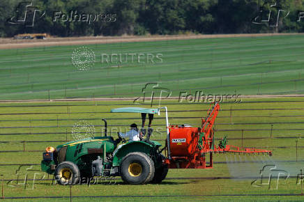 Agricultural worker sprays field in California