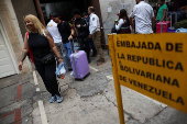 Migrants gather outside the Venezuelan embasssy waiting for a flight back to their country