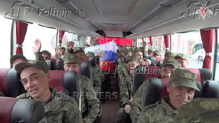 Russian soldiers sit a bus in Belarus after release from Ukraine on the third day of POW exchange