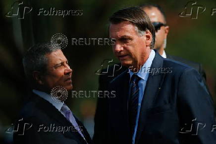 Brazil's President Jair Bolsonaro talks with Brazil's Defence Minister Walter Souza Braga Netto before the 7th day mass in honour of his mother in Brasilia
