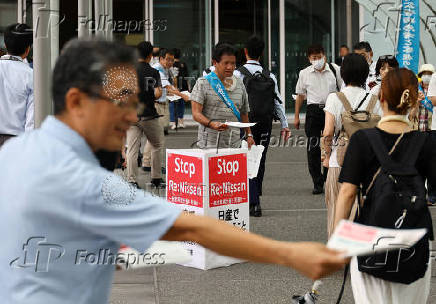 Protesters hand out leaflets against Nissan Motor's turnaround plan in front of the company's global headquarters while its annual shareholder meeting is being held in Yokohama