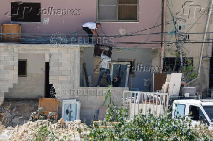 Palestinians carry their belongings after Israel's decision to demolish their homes in Nur Shams camp
