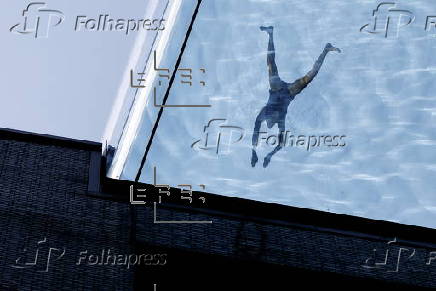 People swim in the Sky Pool during hot weather in London