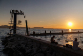 A woman jumps into the Adriatic sea during warm weather in Zadar