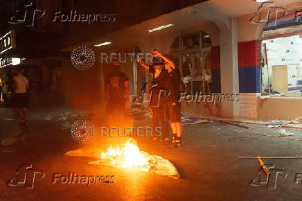 Demonstrators burn posters in front of the Serbian Progressive Party (SNS) ruling party office during a standoff between ruling party  supporters and anti-government protesters in Novi Sad