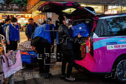 Hong Kong residents affected by the fire gather their belongings from their apartments