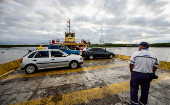 Veículos durante travessia por ferry-boat (balsa) em rio da Barra do Ribeira