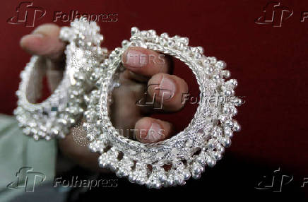 FILE PHOTO: A silver trader displays silver ornaments inside his shop in the western Indian city of Ahmedabad