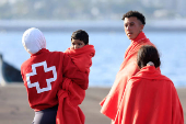 A migrant minor is transferred by the Red Cross after disembarking from a Spanish coast guard vessel, in the port of Arguineguin