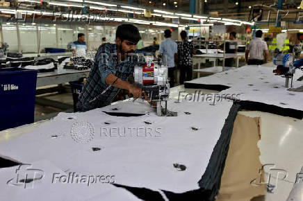 A worker cuts denim fabric in a garment manufacturing unit on the outskirts of Ahmedabad