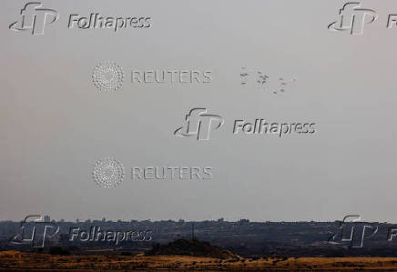 Aid packages dropped from an airplane descend over Gaza