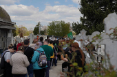People queue up at a tomb bearing the flag with the insignia of the Iron Guard, in Bucharest