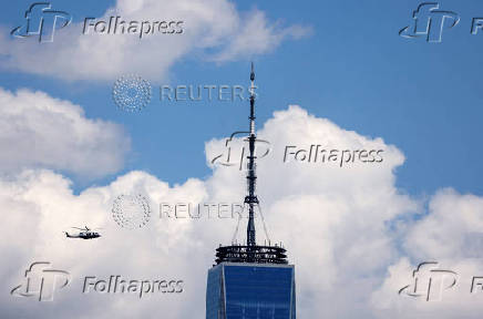 Helicopter flys past the top of the One World Trade Center Tower in New York City
