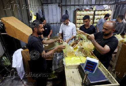 Palestinian workers pack bread in a bakery that returned to operation after being closed due to a flour shortage, in Deir Al-Balah