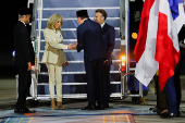 French President Emmanuel Macron and his wife, Brigitte Macron are welcomed by Indonesian Defence Minister Sjafrie Sjamsoeddin, upon their arrival at military airbase Halim Perdanakusuma in Jakarta