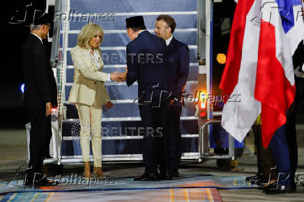 French President Emmanuel Macron and his wife, Brigitte Macron are welcomed by Indonesian Defence Minister Sjafrie Sjamsoeddin, upon their arrival at military airbase Halim Perdanakusuma in Jakarta