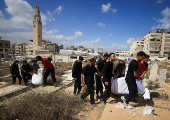 Mourners carry the bodies of members of the Al-Arabeed family killed in Israeli strikes, at a cemetery, in Gaza City