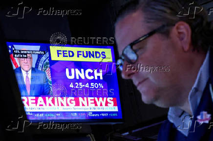 FILE PHOTO: A screen displays the Fed rate announcement as traders work on the floor of the NYSE in New York