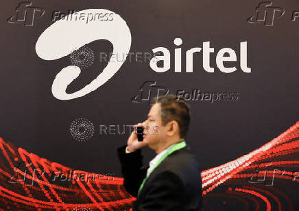 FILE PHOTO: FILE PHOTO: A man walks across the logo of Airtel at the ongoing India Mobile Congress 2025 at Yashobhoomi, a convention and expo center in New Delhi