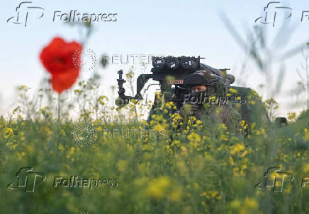 Member of the National Police Special Purpose Battalion stands next to a Partizan multiple rocket launcher before firing towards Russian troops on a front line in Zaporizhzhia Region
