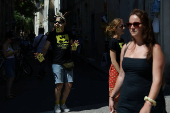 An artist distributes leaflets for a play in a street during the Avignon Festival in Avignon