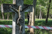 Ukrainian police officer guards the burial site of Poles killed by Ukrainian nationalists during World War II before the upcoming exhumation in the former village of Puzhnyky
