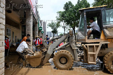 Man operates a front loader during a clean-up operation after heavy rainfall led to flooding in Zhaoqing