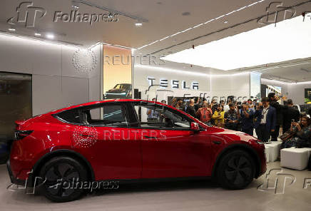 Media personnel take pictures and videos of the TESLA Model Y car at India's first Tesla showroom in Mumbai