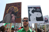 A demonstrator holds signs during a protest against hunger crisis in Gaza, near the embassy of Egypt in Beirut