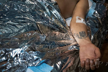 Medics help a wounded Ukrainian serviceman at a medical stabilisation point, near the town of Pokrovsk, in Donetsk region