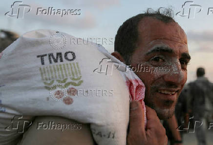 Palestinians gather to receive aid supplies in Beit Lahia