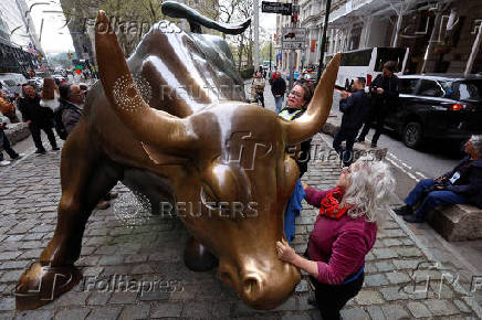 FILE PHOTO: Climate activist clean up after vandalizing Charging Bull, as part of 