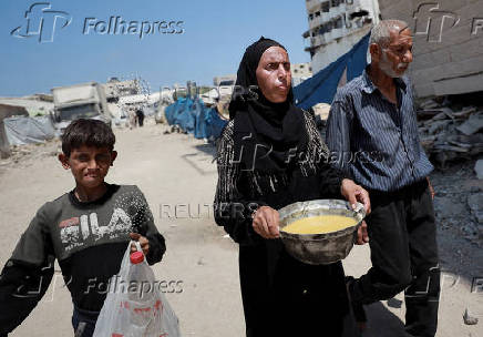 Palestinians wait to receive food from a charity kitchen, in Gaza City