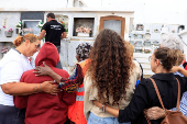 People hug the mother of 12-year-old migrant girl Fatoumatta Banaro during her burial, after the wooden boat she was traveling on sank in the port of La Restinga