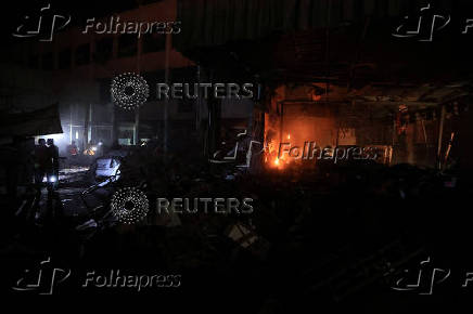 Palestinians inspect the damage at a school sheltering displaced people, in Gaza City