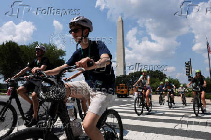Tourists cross a street near the Washington Monument during a heatwave affecting the eastern U.S., in Washington