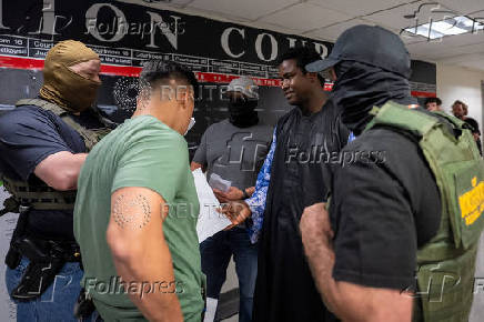 A migrant is detained by federal immigration officers at U.S. immigration court