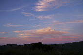 Céu azul, com nuvens de nuances alaranjadas, no penúltimo dia do outono
