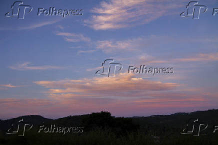 Céu azul, com nuvens de nuances alaranjadas, no penúltimo dia do outono