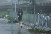 A man walks amid rain as Typhoon Wipha approaches, in Hong Kong