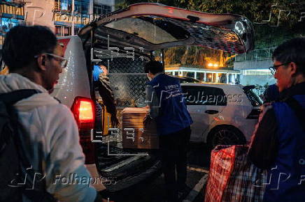 Hong Kong residents affected by the fire gather their belongings from their apartments